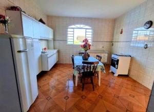 a kitchen with a table and a refrigerator at Espaço da Iza in São Pedro