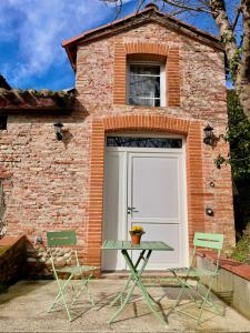 a garage with a white garage door and two chairs at L'Amaryllis, suite romantique Jacuzzi et Parking in Cintegabelle