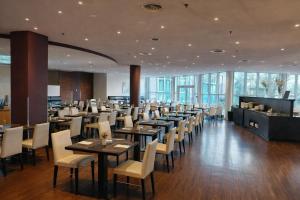 ein Esszimmer mit Tischen, Stühlen und Fenstern in der Unterkunft Hotel Dresden Neustadt in Dresden + 17 Fotos