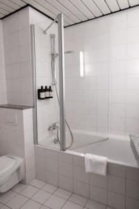 ein weißes Badezimmer mit Badewanne und Toilette in der Unterkunft Hotel Dresden Neustadt in Dresden