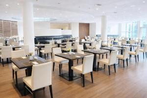 ein Esszimmer mit Tischen und weißen Stühlen in der Unterkunft Hotel Dresden Neustadt in Dresden
