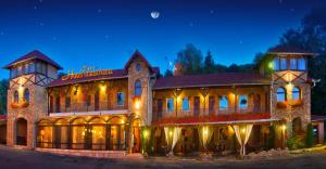 un gran edificio con luces encendidas por la noche en Hotel Transilvania, en Sighişoara