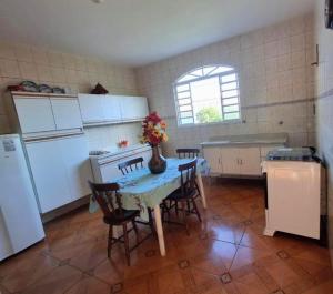 a kitchen with a table with a vase of flowers on it at Espaço da Iza in São Pedro