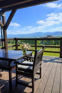 a table and bench on a deck with a view at Domek w górach Łubinowa 6 in Międzylesie