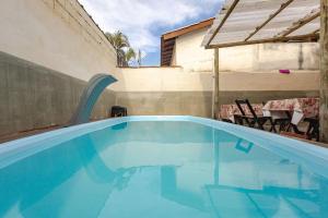 a large blue swimming pool in a backyard at Ilhabela quarto próx praia in Ilhabela