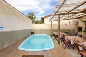 a hot tub on a patio with tables and chairs at Ilhabela quarto próx praia in Ilhabela