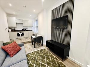 a living room with a couch and a tv and a table at Executive 1-Bed Apartment in Town in Bury