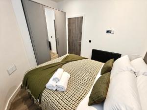 a bedroom with a bed with towels on it at Executive 1-Bed Apartment in Town in Bury