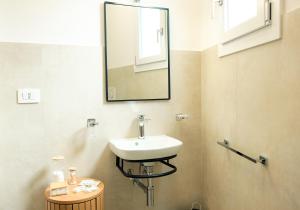 a bathroom with a sink and a mirror on the wall at Saludu Boutique in Porto Torres