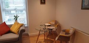 a living room with a table and a couch at Flat 11- The Orchid in Banbury +2 photos