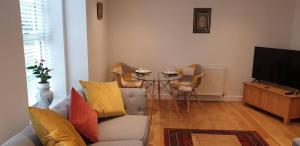 a living room with a couch and a table with chairs at Flat 11- The Orchid in Banbury