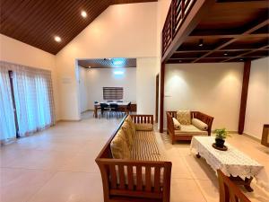 a living room with a couch and a table at Evara Stays Coorg in Kushālnagar