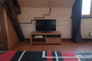 a flat screen tv sitting on top of a wooden cabinet at Le Rêve de Poulaines - Camping Naturiste 1 JUIN - 30 SEPTEMBRE et chambres d'hôtes TOUTE L'ANNÉE in Poulaines