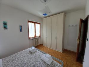 a white bedroom with a bed and a window at Sam's Getaway in Lurisia