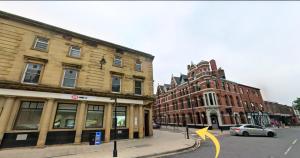 a city street with buildings and a car on the street at Executive 1-Bed Apartment in Town in Bury