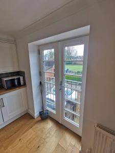 a kitchen with a door with a view of a field at Flat 12- The Meadow in Banbury