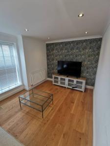 a living room with a flat screen tv and a coffee table at Flat 12- The Meadow in Banbury