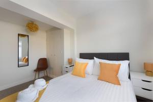 a bedroom with a large white bed with orange pillows at Perfect 3 Bedroom Accommodation for Contractors! in Banbury