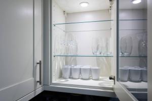 a glass cabinet with many glasses in it at Perfect 3 Bedroom Accommodation for Contractors! in Banbury +32 photos