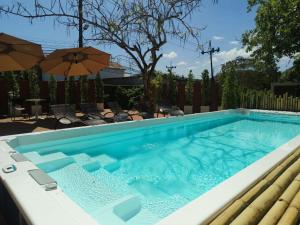 a swimming pool in a yard with an umbrella at NeOtel Apartments in Ban Saiyuan (1)