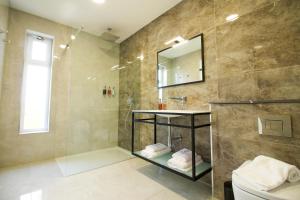 a bathroom with a shower and a sink and a mirror at Pietro Boutique Hotel and Villas in Għarb +27 photos