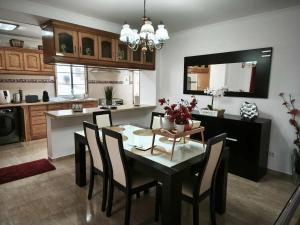 a kitchen and dining room with a table and chairs at Arco-Iris in Santo António