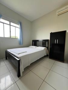 a bedroom with a large bed and a window at Hotel Brilhante 2 in Itacarambi +5 photos