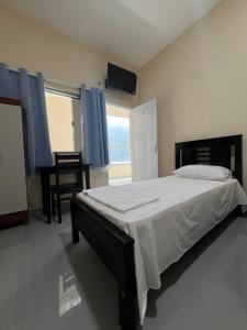 a bedroom with a large bed and a window at Hotel Brilhante 2 in Itacarambi