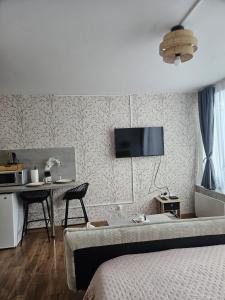 a bedroom with a bed and a desk with chairs at Studio Le Belvédère TURCKHEIM in Turckheim