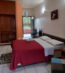 a bedroom with a bed with a red blanket on it at Samaúma Park Hotel in Barcarena +36 photos