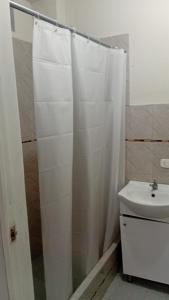 a bathroom with a shower curtain and a sink at Casa Excalibur in Máncora +12 photos