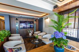 a waiting room with white chairs and purple flowers at Deniz Kızı Urla Otel in Urla