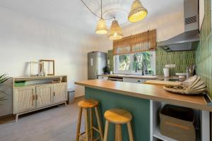 a kitchen with a counter and stools in it at Hauzify I Casa Olivella A in Olivella +14 photos
