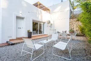a group of white chairs and tables on a patio at Hauzify I Casa Olivella A in Olivella