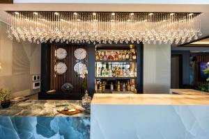 a bar with a chandelier and a bunch of clocks at Deniz Kızı Urla Otel in Urla