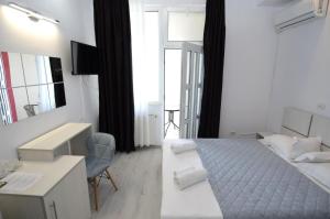 a bedroom with a bed and a desk and a mirror at Vila Julia Costinesti in Costinesti