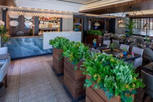 an interior view of a restaurant with tables and plants at Deniz Kızı Urla Otel in Urla