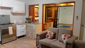 a living room with a couch and a kitchen at Casa Excalibur in Máncora