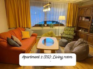 a living room with an orange couch and a table at Angi's Apartment in Sankt Lorenzen ob Murau