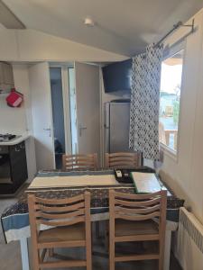 a kitchen and dining room with a table and chairs at Mobil-Home L'Escale-MH34 Les Sables du Midi in Sérignan