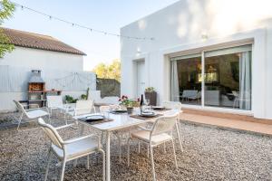 a patio with a white table and chairs on a patio at Hauzify I Casa Olivella A in Olivella