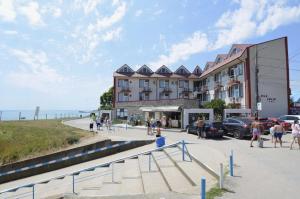 a large building with people walking in front of it at Vila Julia Costinesti in Costinesti