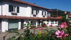 una casa blanca con flores delante en Locanda Verbena, en Stresa