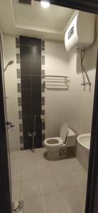 a bathroom with a toilet and a sink at عمارة النفيسة السكنية in Unayzah