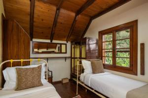 a bedroom with two beds and a window at Antiga Fábrica da Manteiga by An Island Apart in Arco da Calheta