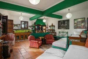 a bedroom with two beds and two chairs at Antiga Fábrica da Manteiga by An Island Apart in Arco da Calheta