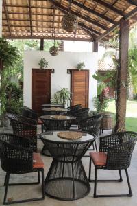 an outdoor seating area with tables and chairs at Condomínio Villa Conduru - Casa completa in Prea
