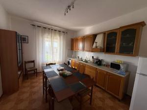 a kitchen with a table and a dining room at B&B Tre di Cuori in Campiano