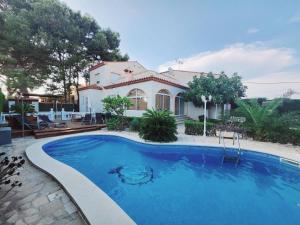 a swimming pool in front of a house at Villa Xaloc piscine privée in Les tres Cales