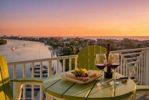 a table with wine glasses and a plate of food at Splash Harbour, Harbourside Waterfront Condo in Clearwater Beach